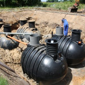 Foto, dass die Einbauarbeiten einer kleinen Kläranlage mit vier Rundtanks zeigt.