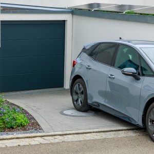 In der Garageneinfahrt parkt ein Auto auf der Schachtabdeckung "PKW-Set" für Erdtanks.